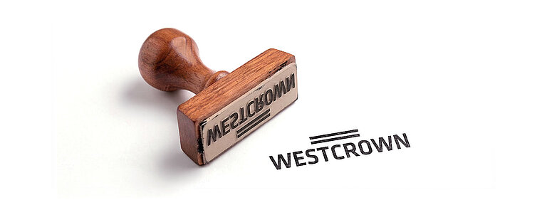 WestCrown-Stempel neben einem gestempelten WestCrown-Logo auf weißem Hintergrund