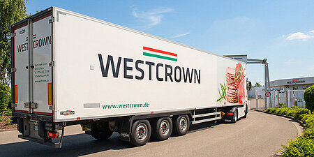 WestCrown-Lkw fährt auf das Werksgelände und passiert die Einfahrt mit WestCrown-Logo.