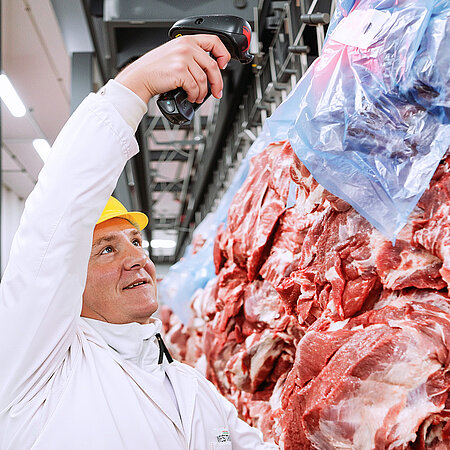 Mitarbeiter von WestCrown scannt verpackte Schweinefleischzuschnitte im Produktions- und Logistikbereich.