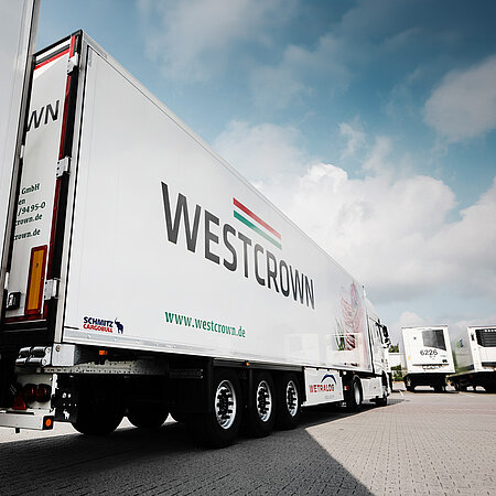 WestCrown-Sattelzug mit großem Markenlogo auf dem Auflieger vor blauem Himmel auf dem Werksgelände.