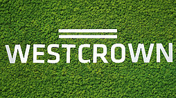 WestCrown-Logo in weißer Schrift auf einem dichten grünen Waldhintergrund.